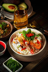 Seafood and rice noodles in cream sauce. Healthy meal made of mussels, octopus meat and other seafood with chilli pepper and rice noodles.