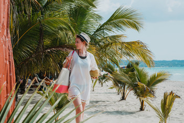 Eine junge Frau spaziert am Strand in der Karibik auf Jamaika
