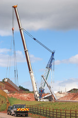 Fototapeta premium Crane lifting a bridge beam