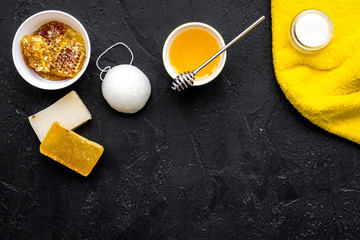 Aromatic theraphy and delicate skin care. Spa set based on honey on black background top view space for text