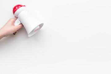 Attract attention concept. Megaphone in hand on white background top view copy space