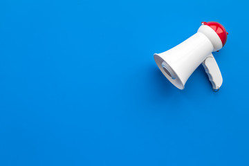 Attract attention concept. Megaphone on blue background top view copy space