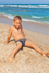 Fototapeta na wymiar boy on the beach with sea on background
