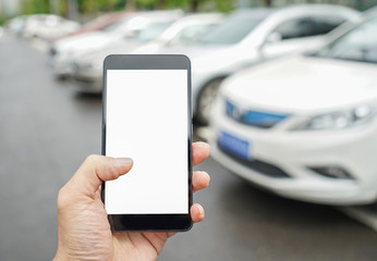 Man calls car with mobile phone APP in parking lot