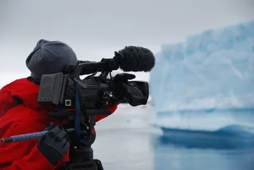Crédence de cuisine en verre imprimé Antarctique Caméraman filmant un iceberg en Antarctique