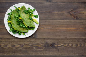 Healthy vegetable pancake. Spinach pancakes on dark wooden background top view copy space