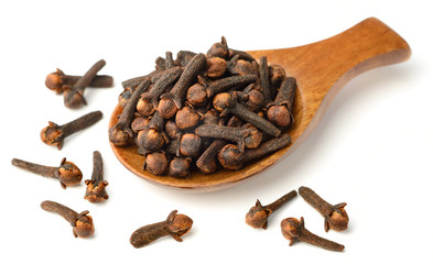 dried cloves in the wooden spoon, isolated on white