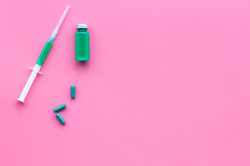 Medical therapy. Syringe, bottle with drug, pills on pink background top view copy space