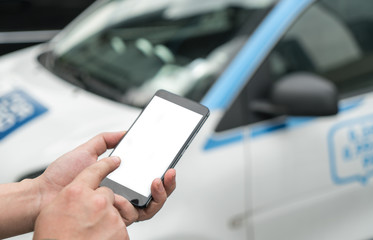 Man calls car with mobile phone APP in parking lot