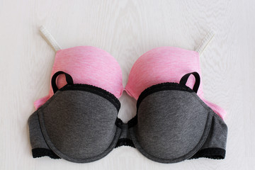 Bra pink sporty and gray with lace on white wooden background