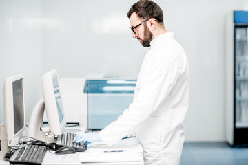 Male technician working with analyzer machine at the laboratiry