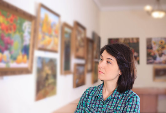 Young woman looking at painting.
