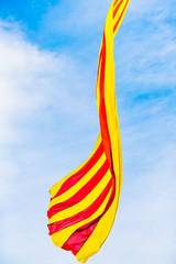 Flag of Catalonia waving in the wind against the sky