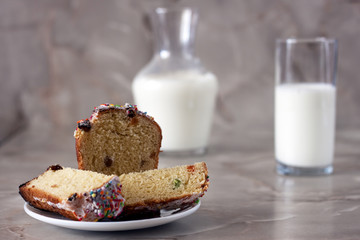 Delicious aromatic cake and a glass of milk on a table with a marbled background.