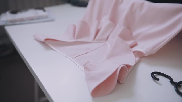 Seller fold a dress on a table