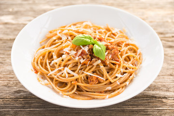 Piatto di spaghetti condito con carne, pomodoro e parmigiano 