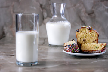 Delicious aromatic cake and a glass of milk on a table with a marbled background.