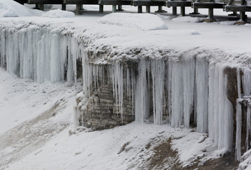 Lengthy icicles flowing over edge near geyser walkway