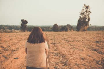 Portrait of lonely woman alone in a field. Vintage filter style.she heartbreak from love,sad girl concept on sunset vintage style