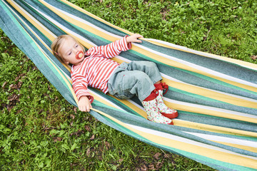 Fototapeta na wymiar Little girl having a rest in a hammock 