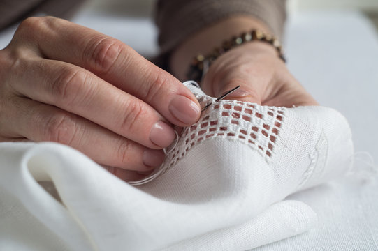 Woman's hands embroider ornaments