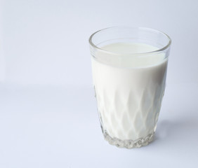 Faceted glass of milk on a gray background