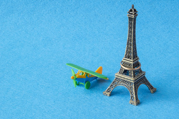 Eifel tower model with toy plane. Famous French landmark and airplane miniatures, paris souvenirs concept.