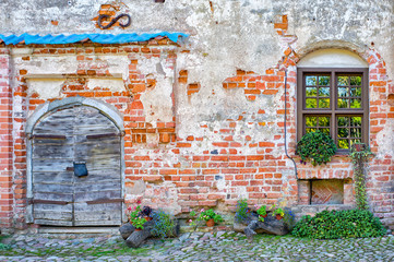 Fototapeta na wymiar Old door and new window in an old brick wall