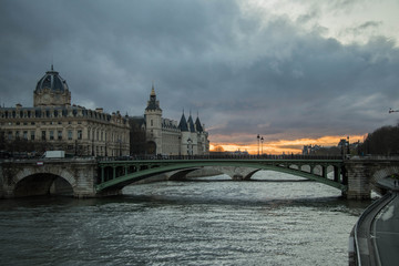 beautiful Parisian bridge against the backdrop of a magically setting sun seen in the early windy spring evening