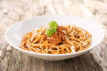 Piatto di spaghetti condito con carne, pomodoro e parmigiano 