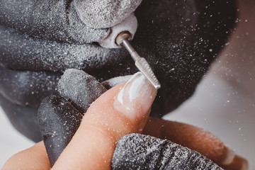 Fototapeta premium Manicure. Master applies varnish drawing on nails gel in manicure salon.
