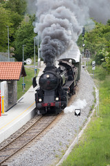 Obraz premium Old Steam Train passes a small Railway Station, Solkan, Nova Gorica, Slovenia, Soca river