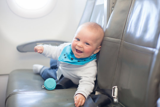 Cute little baby boy, playing with toys on board of aircraft