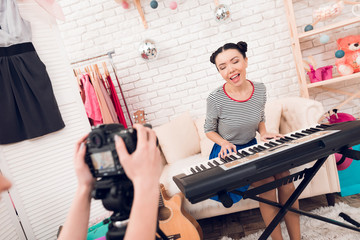Two fashion blogger girls play keyboard with one girl behind camera.