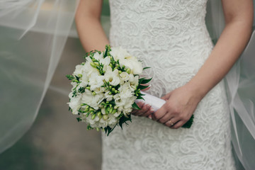 Obraz na płótnie Canvas Wedding bouquet of white flowers in the bride's hands
