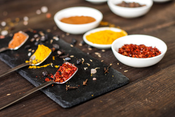 Spices and herbs. Variety of spices and herbs on a dark wooden surface