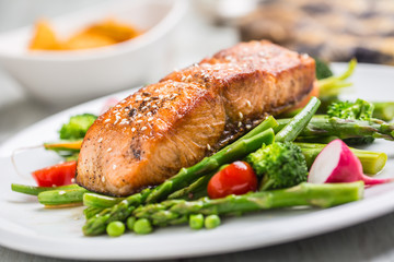 Roasted salmon steak with asparagos broccoli carrot tomatoes radish green beans and peas. Fish meal...