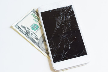 Mobile phone with a broken display on a hundred-dollar bill