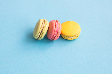 Macaroons, pink, yellow and green macaroons on blue background. Bright and colorful concept. Copyplace, place for text.
