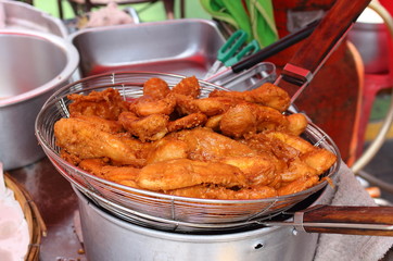 Deep fried banana on a metal grill for draining oil for sale to the counter of the Asian street market.