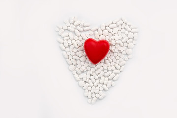 Scattered white tablets with red heart on it, isolated