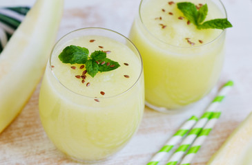 Cold fresh melon smoothies with mint in glass, summer drink beverage, healthy food concept, freshness, exotic fruits