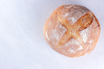 Bread baked in wood stove, white bread on white background, golden crust, bread bakery for designer, agriculture, wheat flour, white wooden background, food, French cuisine
