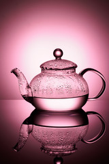 Glass teapot with boiling water and drops of condensation