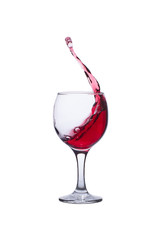 The red wine splashes out of the glass isolated on a white background