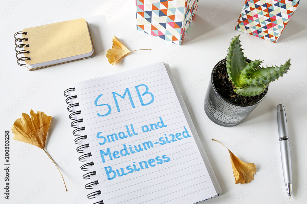 Poster smb small and medium-sized business written in a notebook on white table