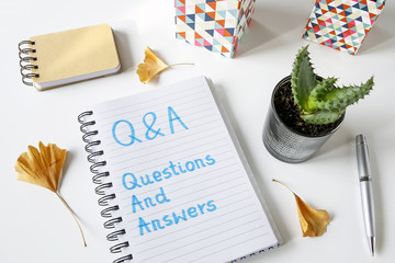 Q&A questions and answers written in a notebook on white table