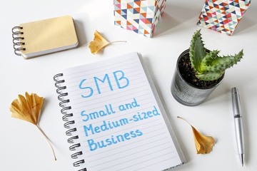 SMB Small And Medium-sized Business written in a notebook on white table