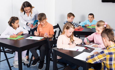 Children in elementary age drawing together at classroom