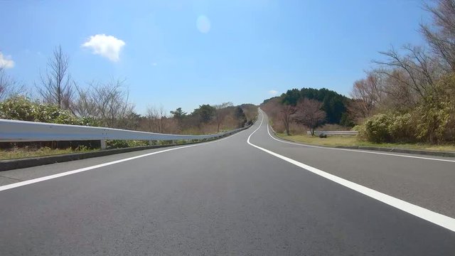 Driving on winding mountain road in spring